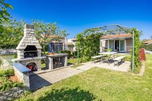 a backyard with a stone fireplace and a table and chairs at House Kacana in Vodnjan