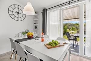 a kitchen and dining room with a white table and chairs at House Kacana in Vodnjan