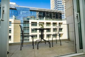 a table and chairs on a balcony with a window at Boulevard Abdali view Luxury apartment in Amman