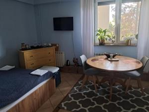 a bedroom with a bed and a table and a bed and a table and chairs at Cottage Room- Agroturystyka in Strzegowo-Osada
