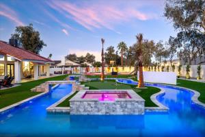 a swimming pool with a fountain in the middle of a yard at Lazy River Luxe 6 BR Sleeps 16 Pickleball Hot Tub in Glendale