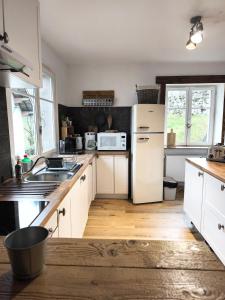 eine Küche mit weißen Schränken und einem weißen Kühlschrank in der Unterkunft Maison de montagne-Ski, randos Proche Gérardmer in Le Valtin
