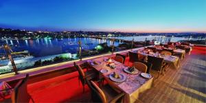 فندق جولدن سيتي اسطنبول في إسطنبول: مطعم به طاولات وكراسي ومطل على الماء