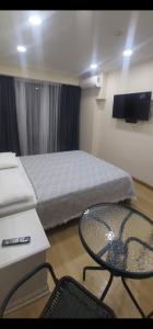 a room with a bed and a table and a tv at Orbi Beach Tower in Batumi +18 photos