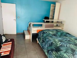 a bedroom with a bed with a desk and a bed sidx sidx sidx at Chambre spacieuse Pour 2 personnes chez l habitant in Pointe-à-Pitre