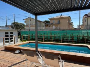 a swimming pool with two chairs sitting on a deck at Dimora degli Ulivi in Rimini