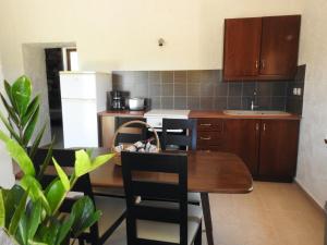 eine Küche mit einem Holztisch und Stühlen in der Unterkunft The Stone Cottage Kos in Kos-Stadt