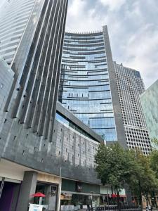 un edificio alto frente a un edificio grande en Residencias Plaza, en Ciudad de México