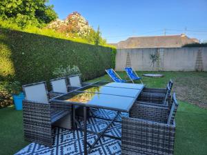 eine Terrasse mit Tisch und Stühlen in einem Hof in der Unterkunft La Thibaudière - Maison familiale in Montreuil-Bellay
