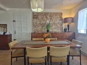 ein Esszimmer mit einem Holztisch und Stühlen in der Unterkunft La Thibaudière - Maison familiale in Montreuil-Bellay