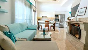 a living room with a couch and a fireplace at Turquoise Front Sea Apartment in Kokkíni Khánion