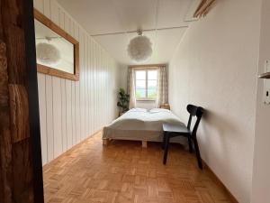 a bedroom with a bed in the corner of a room at Bauernhaus mit Traumblick über Bern in Bolligen