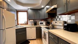 a kitchen with black cabinets and white appliances at Mountains Getaway in Campton