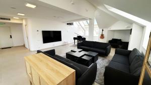 sala de estar con muebles negros y TV de pantalla plana en Casa Damadian, en Constanţa 21 fotos más