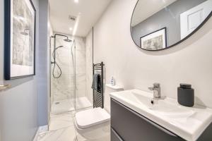 ein weißes Badezimmer mit Waschbecken und Spiegel in der Unterkunft 3-Bed Flat Free Parking 10 Mins to City Centre in Glasgow