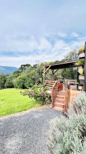 a house with a wooden staircase and a gazebo at TinyFloresta- Pousada Cachoeira da Neve in Urubici