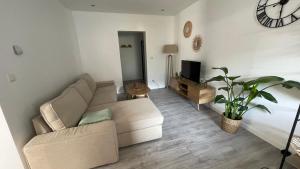 a living room with a couch and a tv at Gîte proche Cattenom, Luxembourg in Algrange