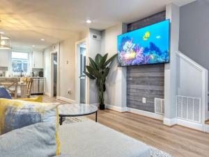 a living room with a flat screen tv on a wall at Elegant Home 8 mins to Washington DC & and Old Town! in Alexandria