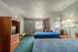 une chambre d'hôtel avec deux lits et une télévision dans l'établissement Economy Inn By OYO Livingston TX Hwy 59, à Livingston