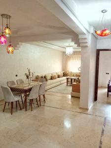ein Wohnzimmer mit Tisch, Stühlen und Sofa in der Unterkunft Appartement en plein centre in Marrakesch
