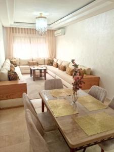 ein Wohnzimmer mit Tisch und Couch in der Unterkunft Appartement en plein centre in Marrakesch