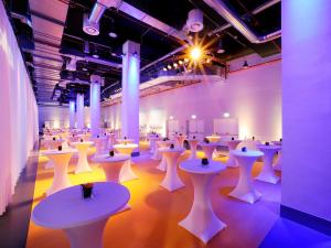 a large room with white tables and white stools at Vienna House by Wyndham Andel's Berlin in Berlin