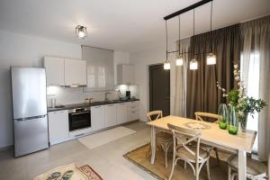 a kitchen and dining room with a table and refrigerator at Kotrona Apartments in Kalavrita +40 photos
