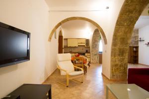 ノート・マリーナにあるAgriturismoeloropizzutaのアーチ道と白い椅子付きのリビングルーム