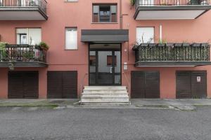 Un edificio rosa con una puerta y escaleras al frente. en Easy Venice - Flat in Mestre, en Venecia