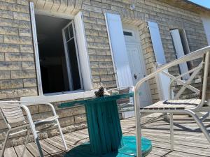 a patio with a table and chairs on a porch at Brise des dunes in Saint-Pierre-dʼOléron