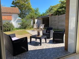 a patio with chairs and a table with a vase on it at Brise des dunes in Saint-Pierre-dʼOléron +34 photos