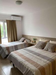 a hotel room with two beds and a window at Complejo Pampa 1 in Santa Rosa
