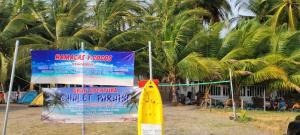 een bord voor een resort met palmbomen bij Chalet Paraiso Compartido in Tulate