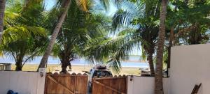 een auto geparkeerd voor het strand met palmbomen bij Chalet Paraiso Compartido in Tulate