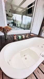 a white bath tub in a bathroom with a window at Amanhecer - Essenziale in Urubici