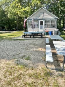 a house with a picnic table and an american flag at HARMON'S BEACH LIMIT 5 villa in Standish