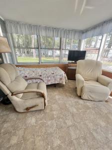 a living room with two chairs and a bed at HARMON'S BEACH LIMIT 5 villa in Standish +8 photos
