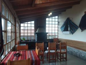a dining room with a table and chairs and a fireplace at Hostal Casa Cotopaxi in Latacunga
