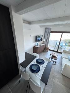 a living room with a table and a couch at TheView108, Rena Bianca in Baja Sardinia
