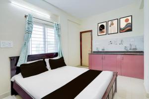 a bedroom with a large bed and a window at Paradise Living in Bangalore