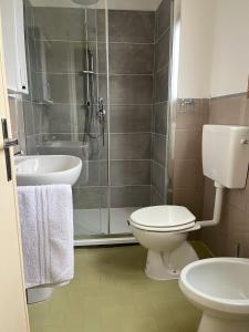 a bathroom with a shower and a toilet and a sink at Inti in Lucca