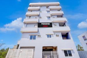 a white building with a sign on it at Paradise Living in Bangalore