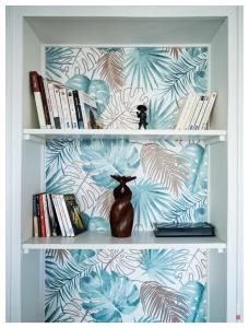 une étagère avec des livres et un vase dessus dans l'établissement 4 pièces avec terrasse- 1 min du métro - Paris, à Charenton-le-Pont