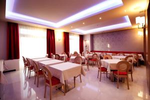 a dining room with white tables and chairs at Hotel Raca in Sesvete