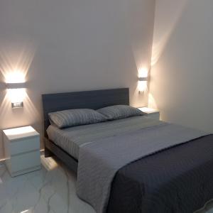 a bedroom with a bed with two lights on it at Jenny's house in Castellammare di Stabia