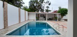 a swimming pool in front of a house at Villa Roy in Santa Marta