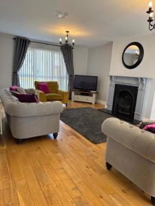 a living room with two couches and a television at Pear Tree Cottage, Portstewart in Portstewart