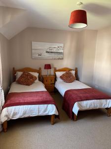 a bedroom with two beds and a red lamp at Pear Tree Cottage, Portstewart in Portstewart