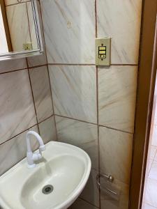 a bathroom with a white sink and a mirror at 24 - Kitnet com cozinha e ventilador - 2 andar in Paragominas +3 photos