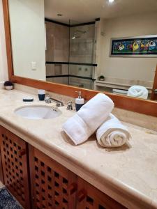 プエルト・アベントゥラスにあるMagnificent Penthouse Jacuzzi, Beach Access & Wifiの洗面台と鏡を備えたバスルームのカウンター